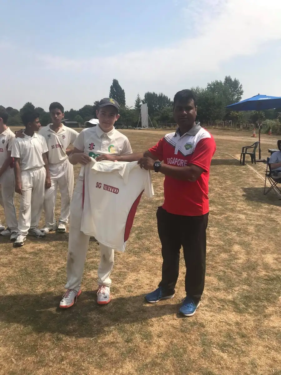 Coach presenting jersey to Singapore United Cricket Club player